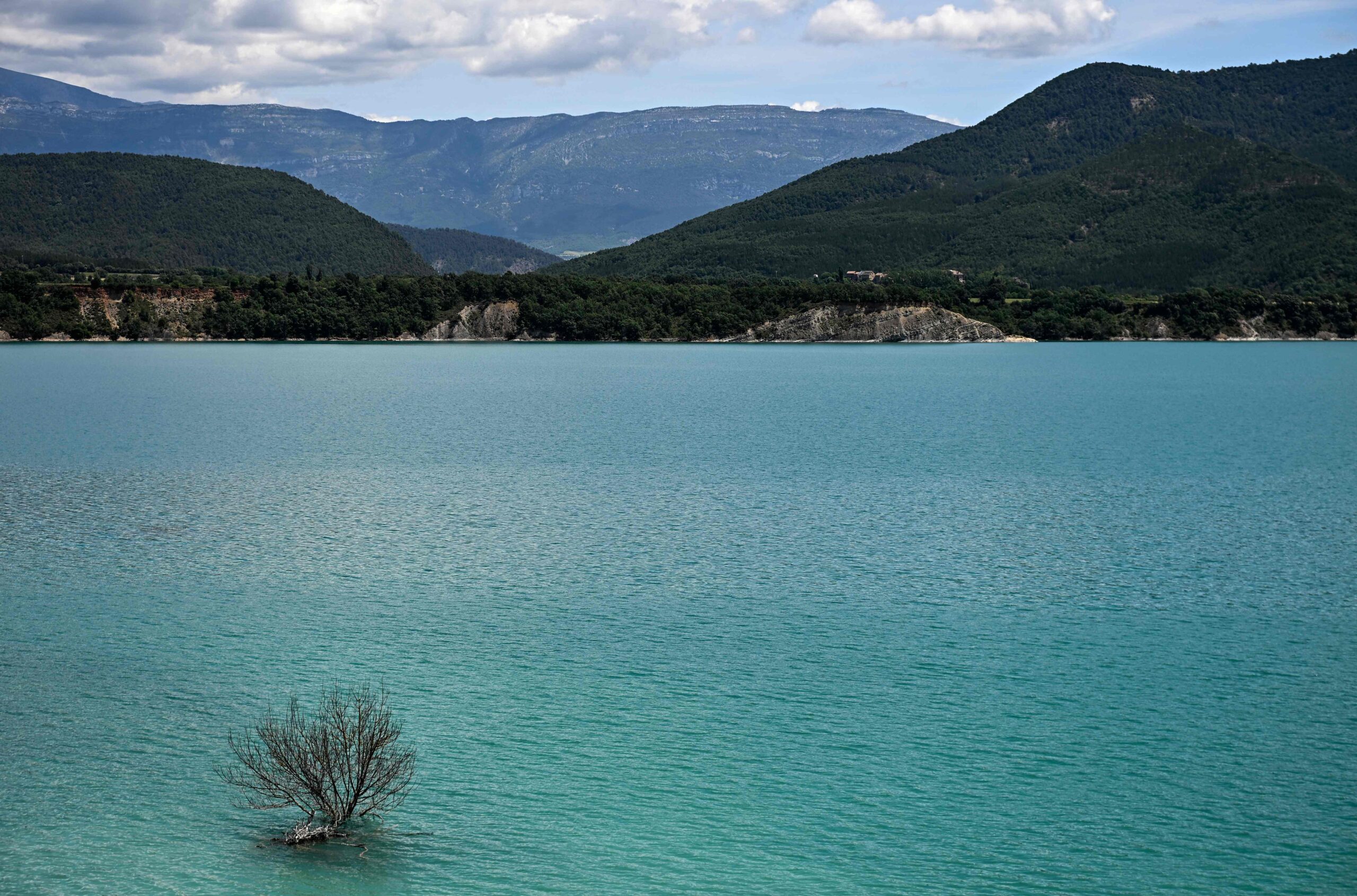 This photograph taken on May 19, 2026 shows a view of the Mediano reservoir amid high water level, in Mediano, Huesca province. This long-term project shows an inventory of several sites in Spain which are suffering from drought. Photos of the same places are taken every month over a very long period. (Photo by ANDER GILLENEA / AFP)